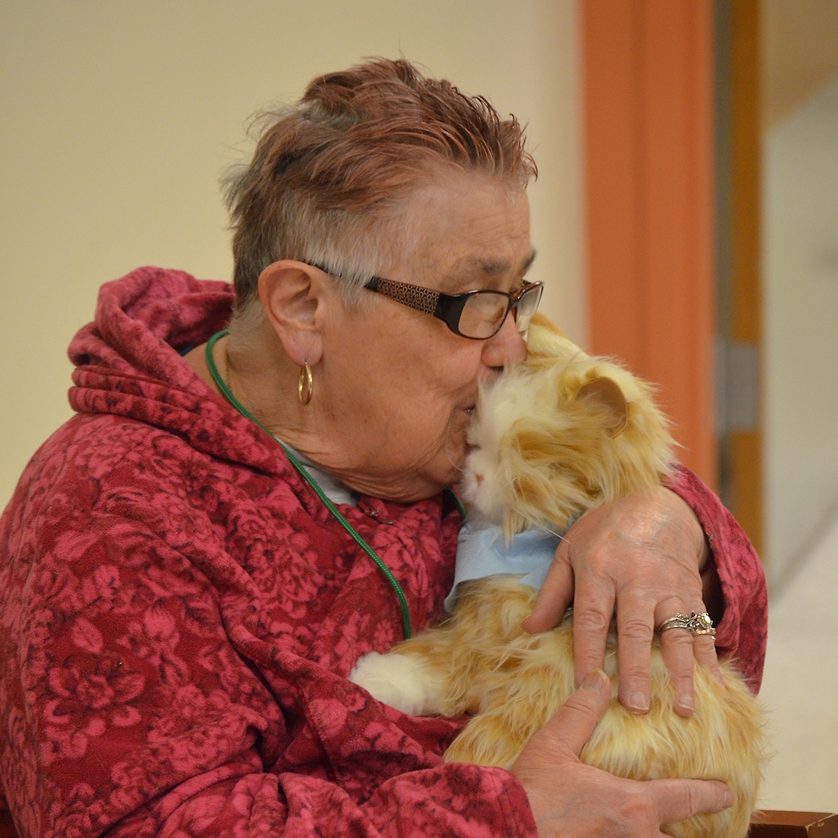 Woman holding an Ageless Innovation cat, as part of the Pilot Pet Program
