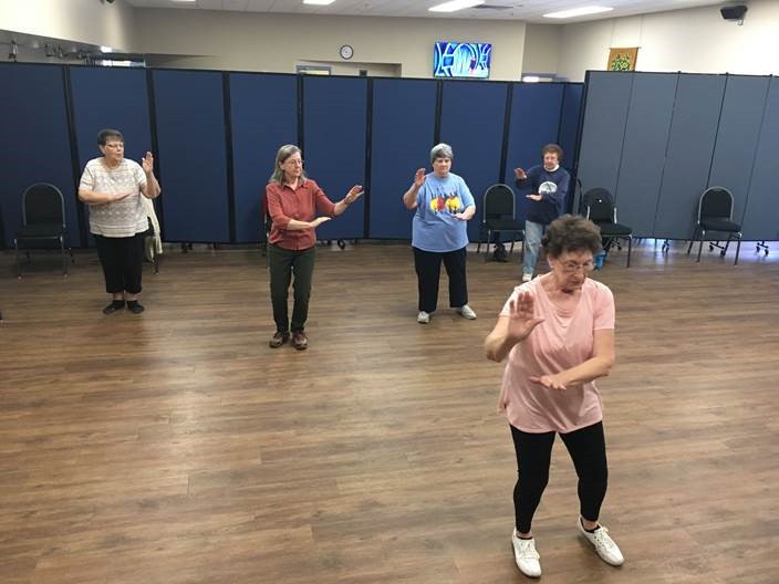 Tai Chi Class volunteers being led by Sylvia Say in front