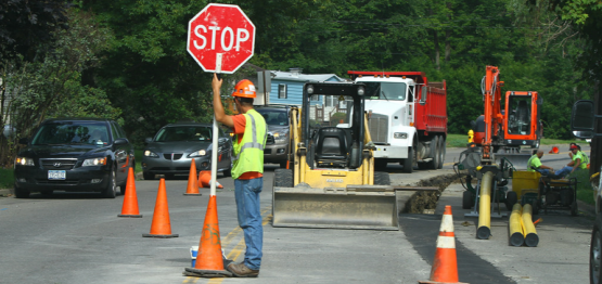road worker guiding traffic near a construction site
