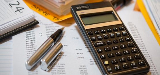 pen and calculator on top of a finance list